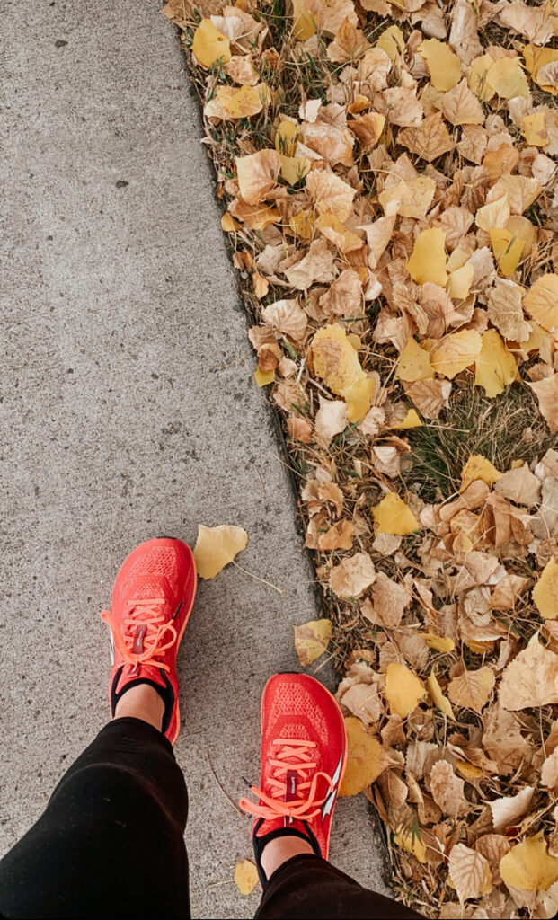 benefits to walking daily. Walking on pavement next to fall leaves